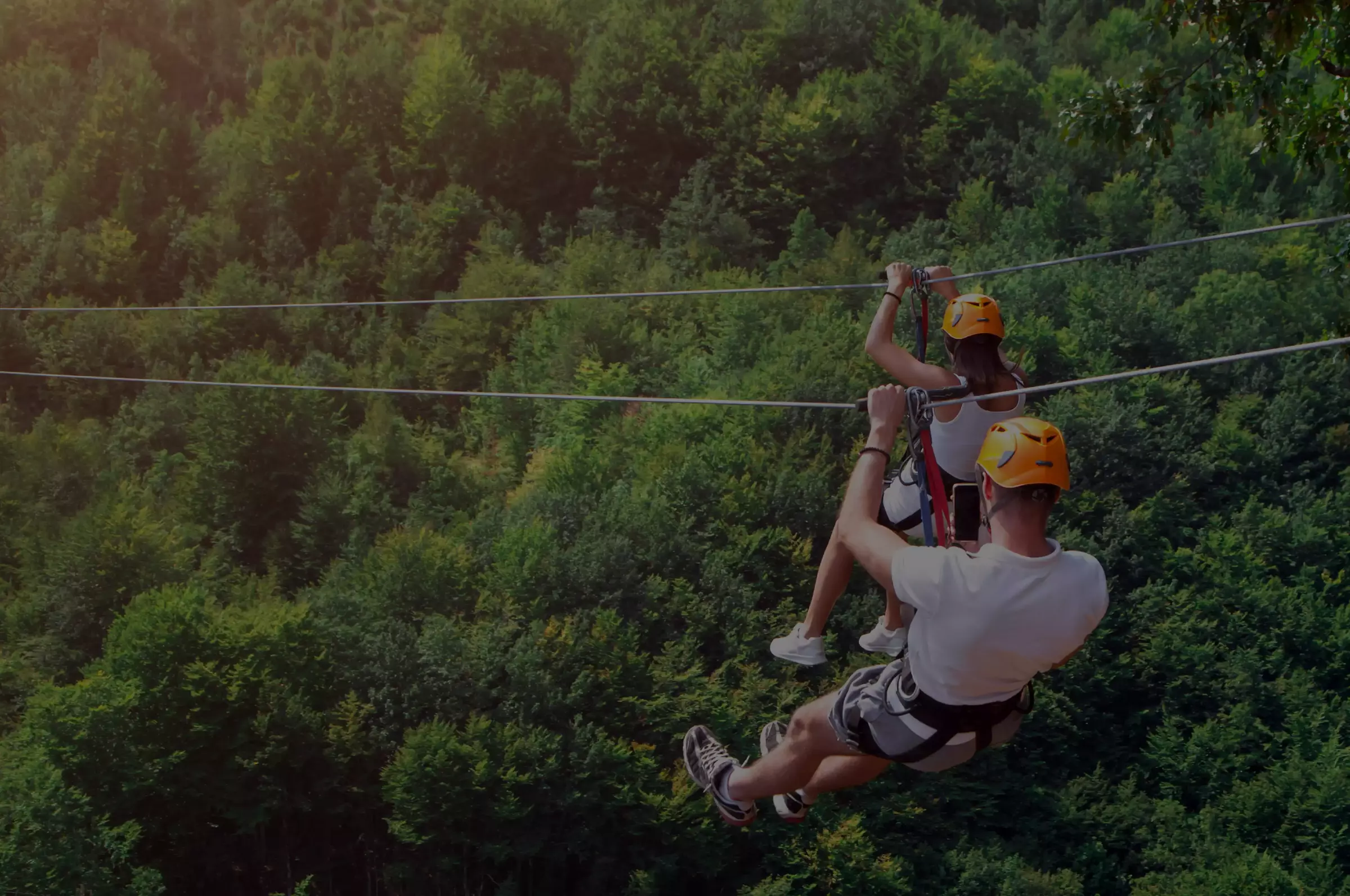woman zip lining above the trees