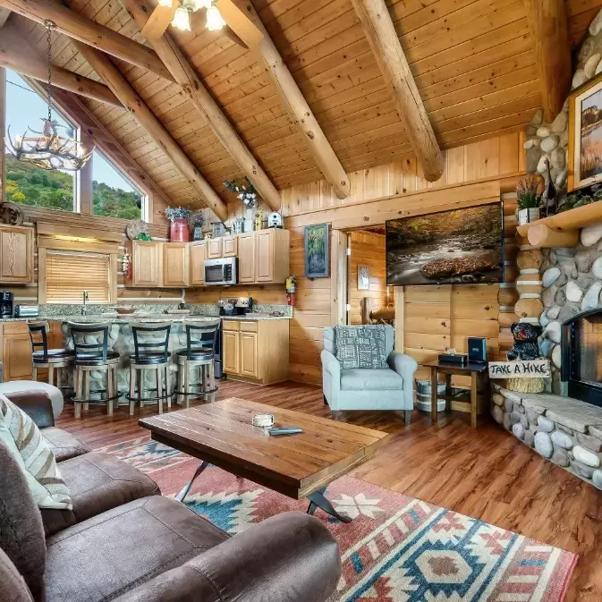 living room and kitchen inside cabin with fireplace
