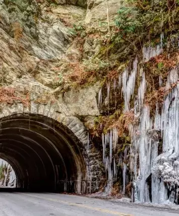 frozen waterfall next to a tunnel