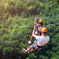person zip lining above trees