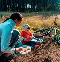 woman and child eating a snack on a break during bicycle ride